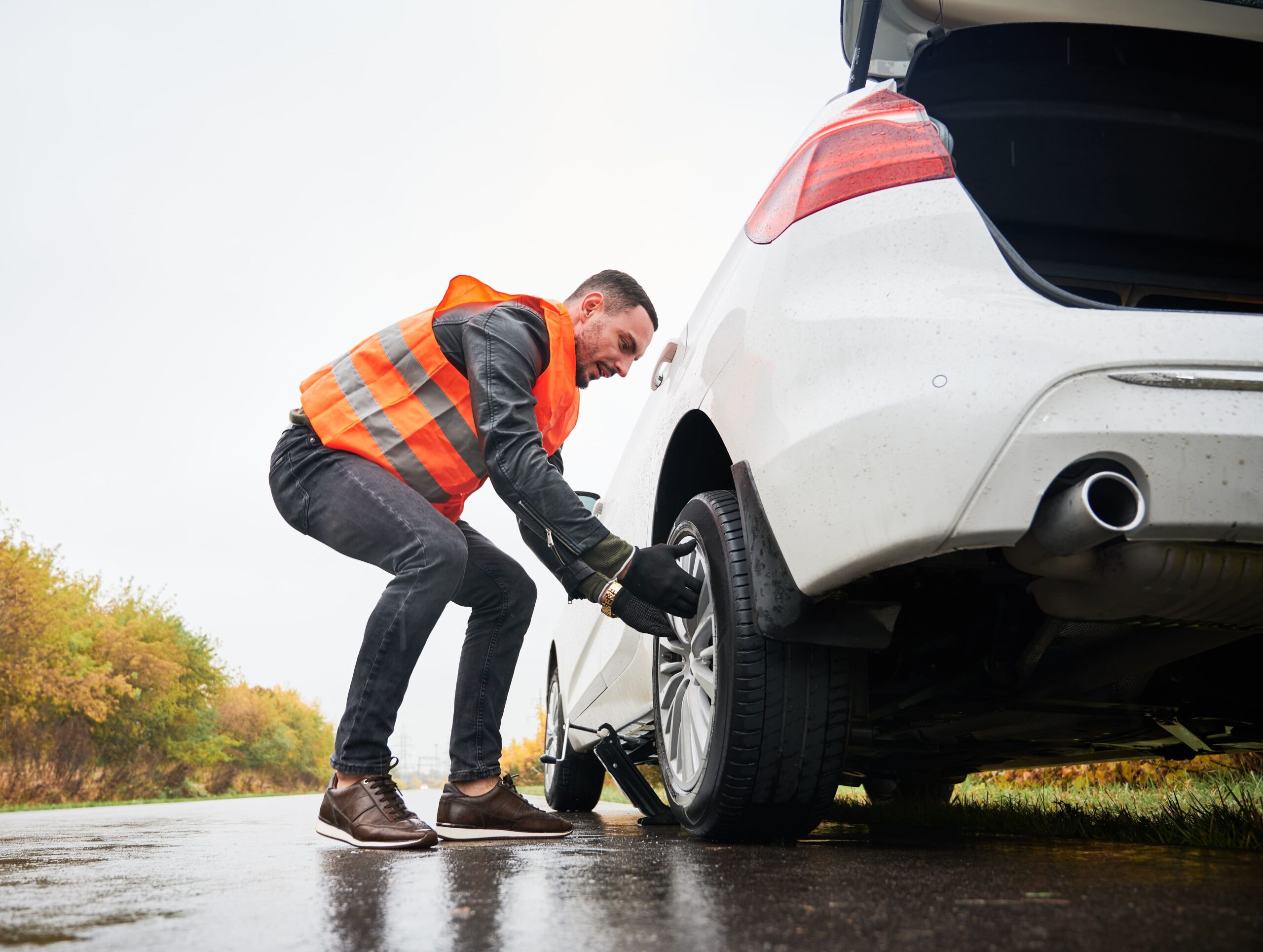 emergency-auto-mechanic-changing-flat-tire-road (1)